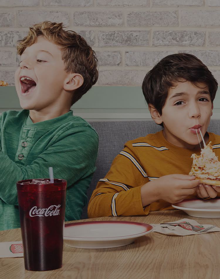 Three young boys enjoying LaRosa's pizza.