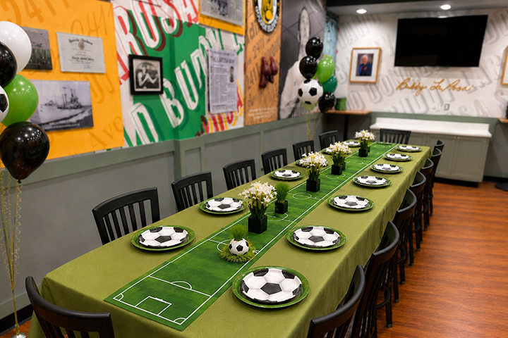 Party room with one long table with sports-themed decor.